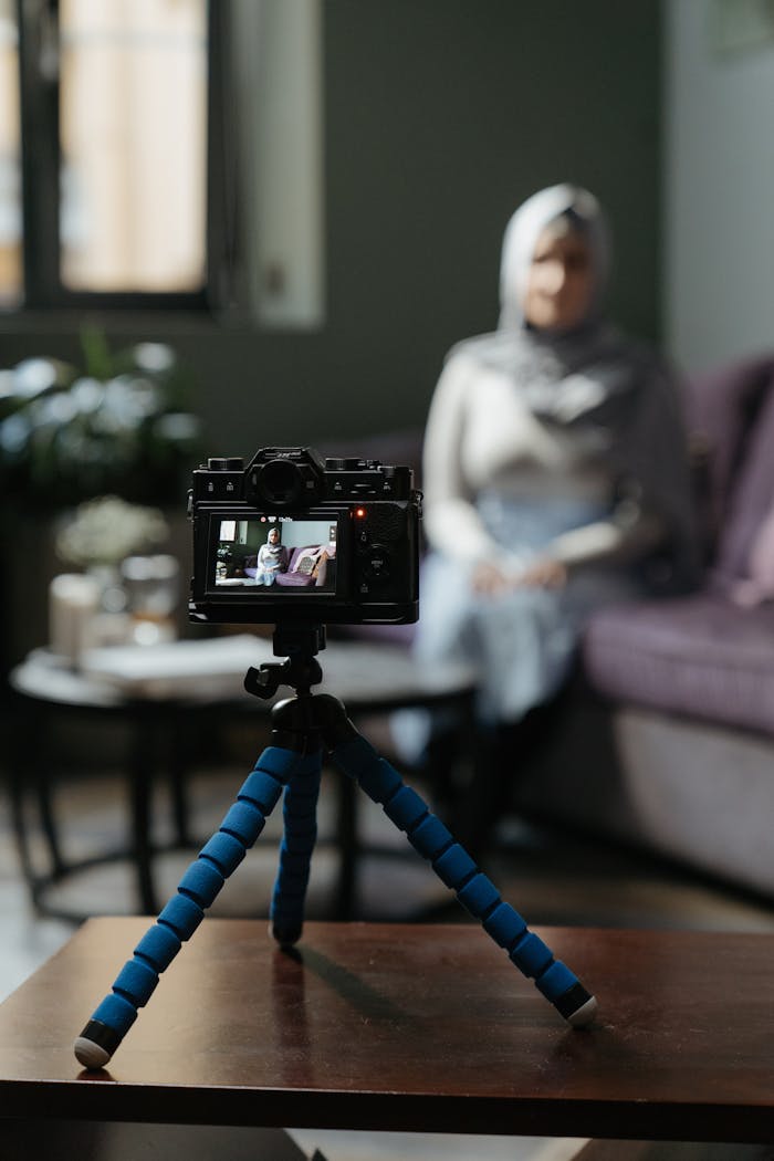 story-02 Camera on a tripod filming a woman in a cozy living room setting for a vlog.